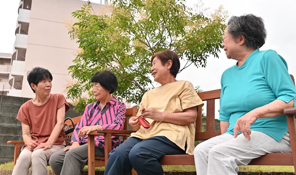 ベンチに腰かけて笑顔で語り合う地域のみなさん