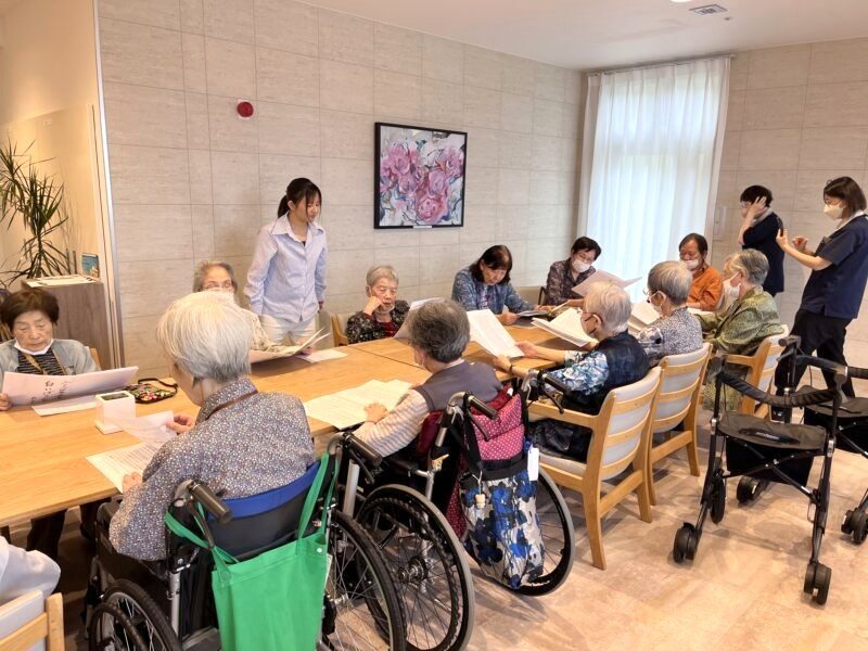 テーブルを囲んで朗読クラブに参加する利用者のみなさん