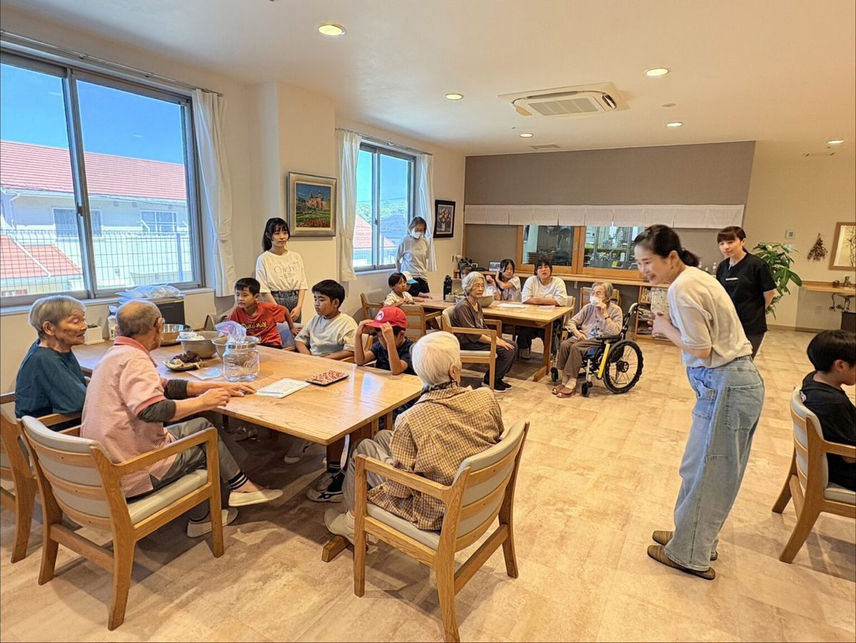 大きなテーブルを囲んで子どもと高齢者が交流するかいごTERAKOYA